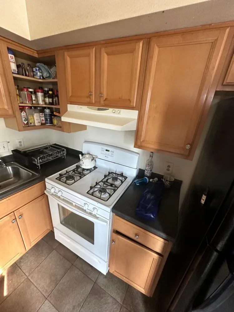 a white stove top oven sitting inside of a kitchen