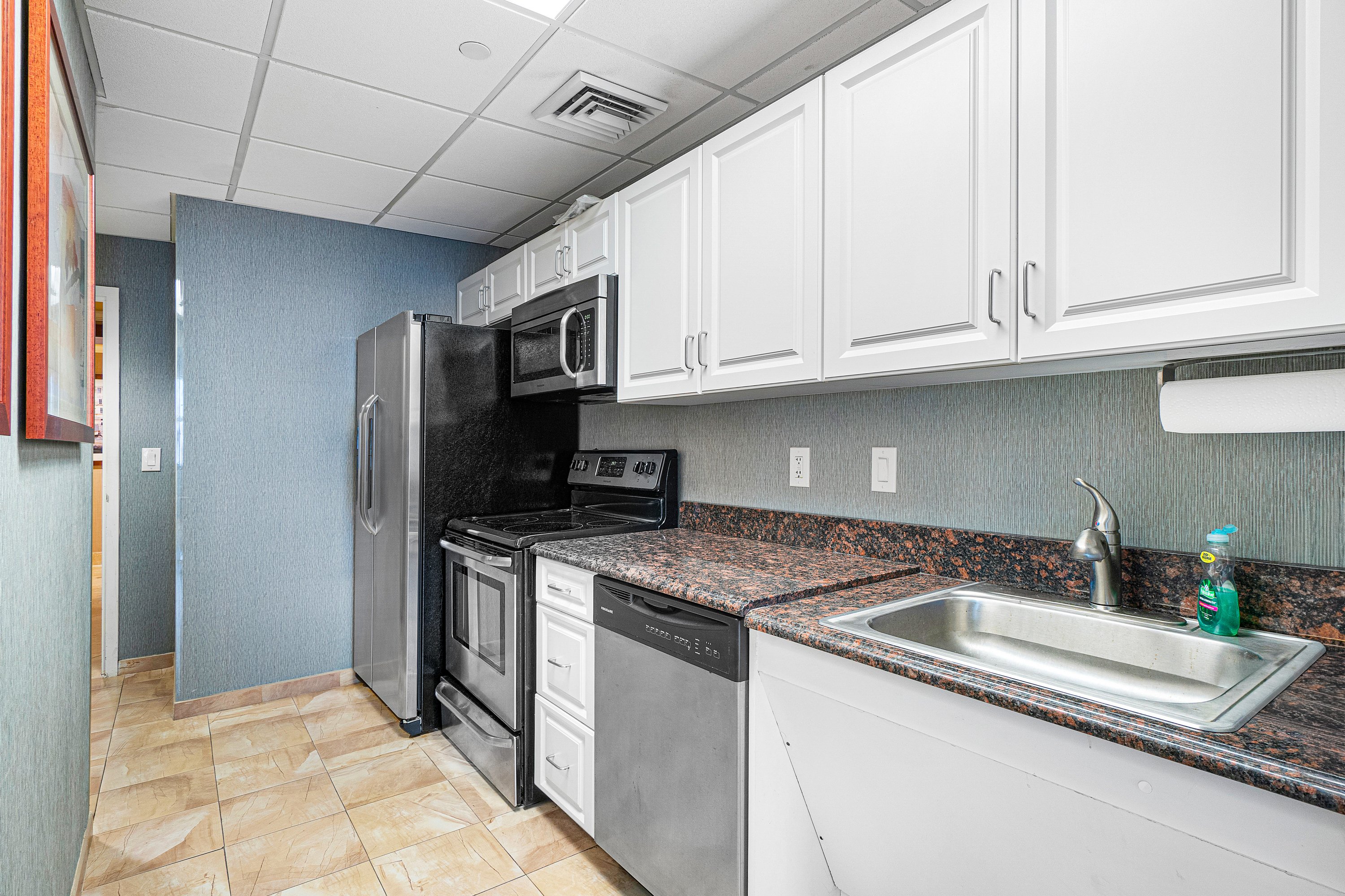 2003 North Ocean Boulevard, Unit 305 Boca Raton, FL 33431 - Photo 47 of 56 a kitchen with stainless steel appliances granite countertop a sink stove and refrigerator