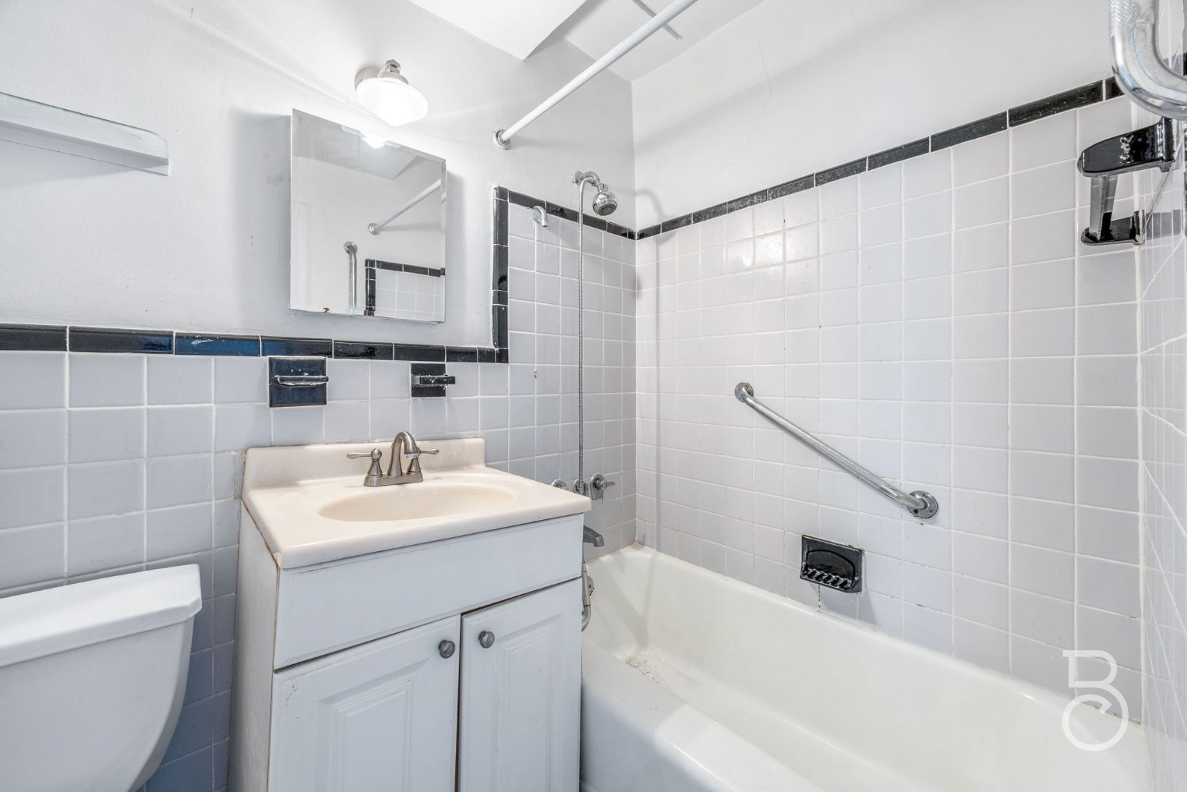 33-47 14th Street, Unit 6D Queens, NY 11106 - Photo 8 of 12 a bathroom with a sink a vanity a toilet a mirror and shower