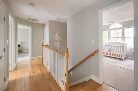 a view of a hallway with wooden floor and windows