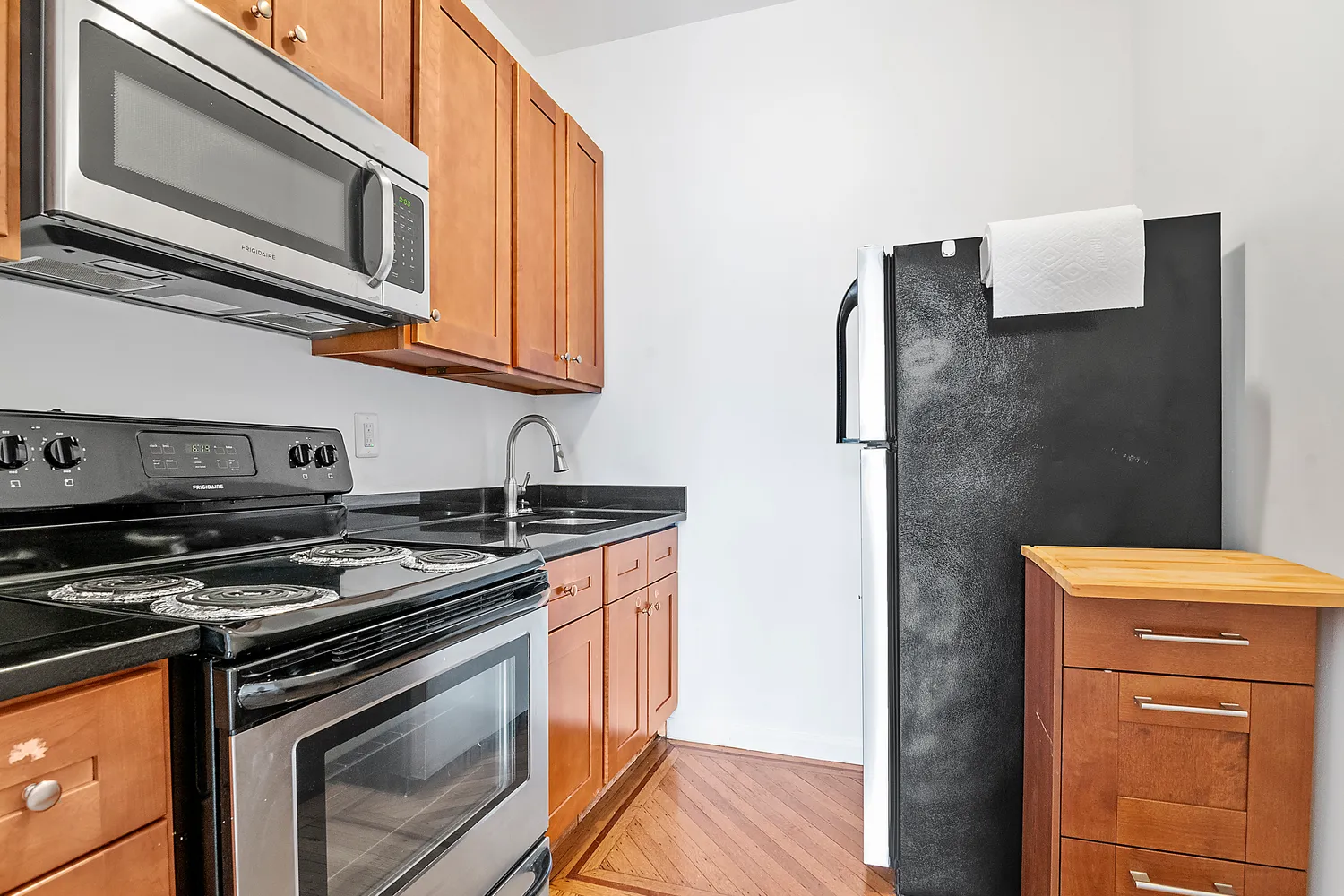 a kitchen with stainless steel appliances granite countertop a stove microwave and refrigerator