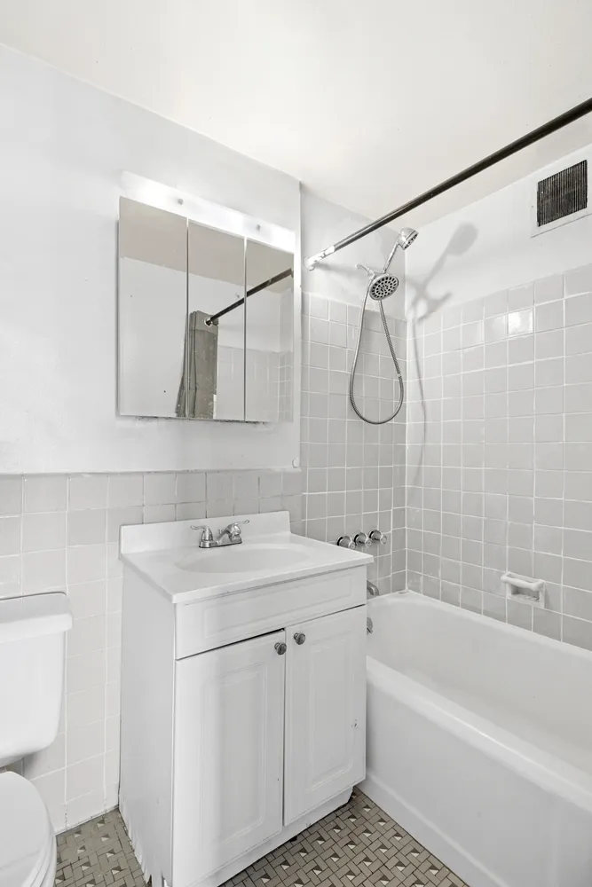 a bathroom with a sink toilet vanity and shower