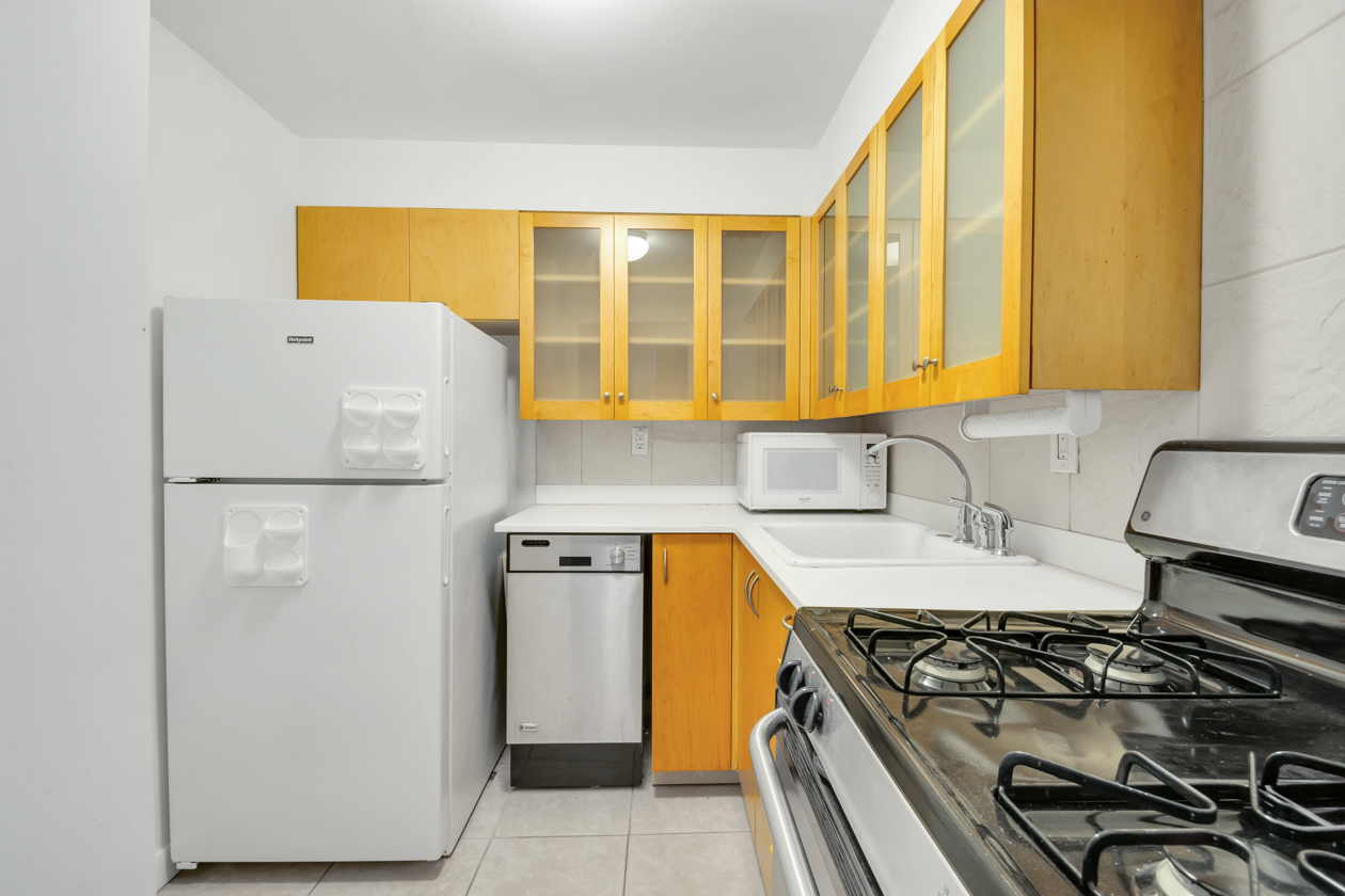 65 Cooper Square, Unit 3D Manhattan, NY 10003 - Photo 8 of 11 a kitchen with a stove a refrigerator and a sink