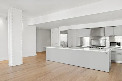 a view of kitchen with stainless steel appliances a sink and wooden floor