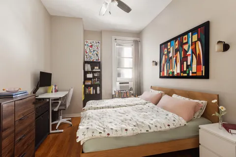 a bedroom with a bed and a bookshelf