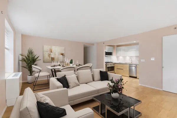 a living room with furniture white walls and a dining table with kitchen view
