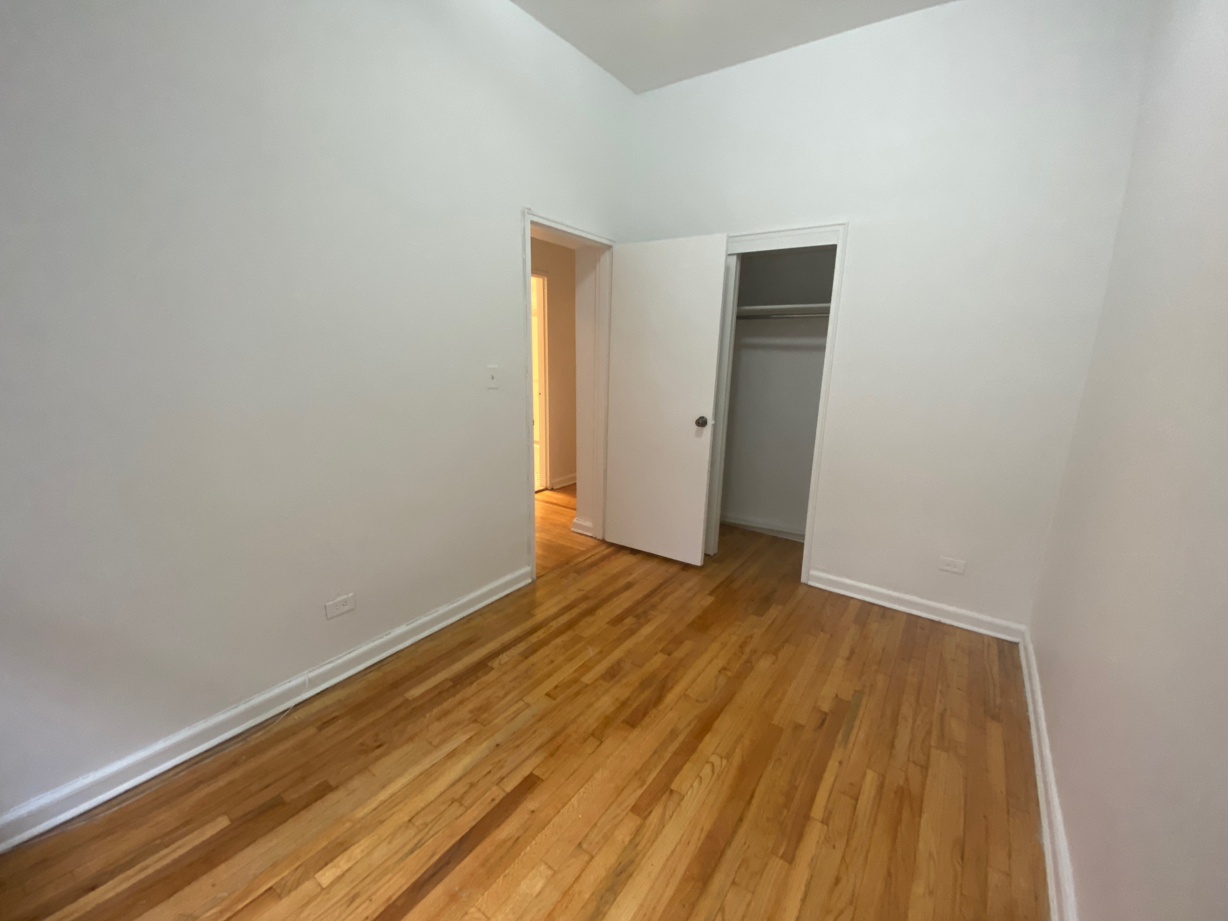 1240 Lexington Avenue, Unit 34 Manhattan, NY 10028 - Photo 10 of 11 a view of an empty room with wooden floor and a window
