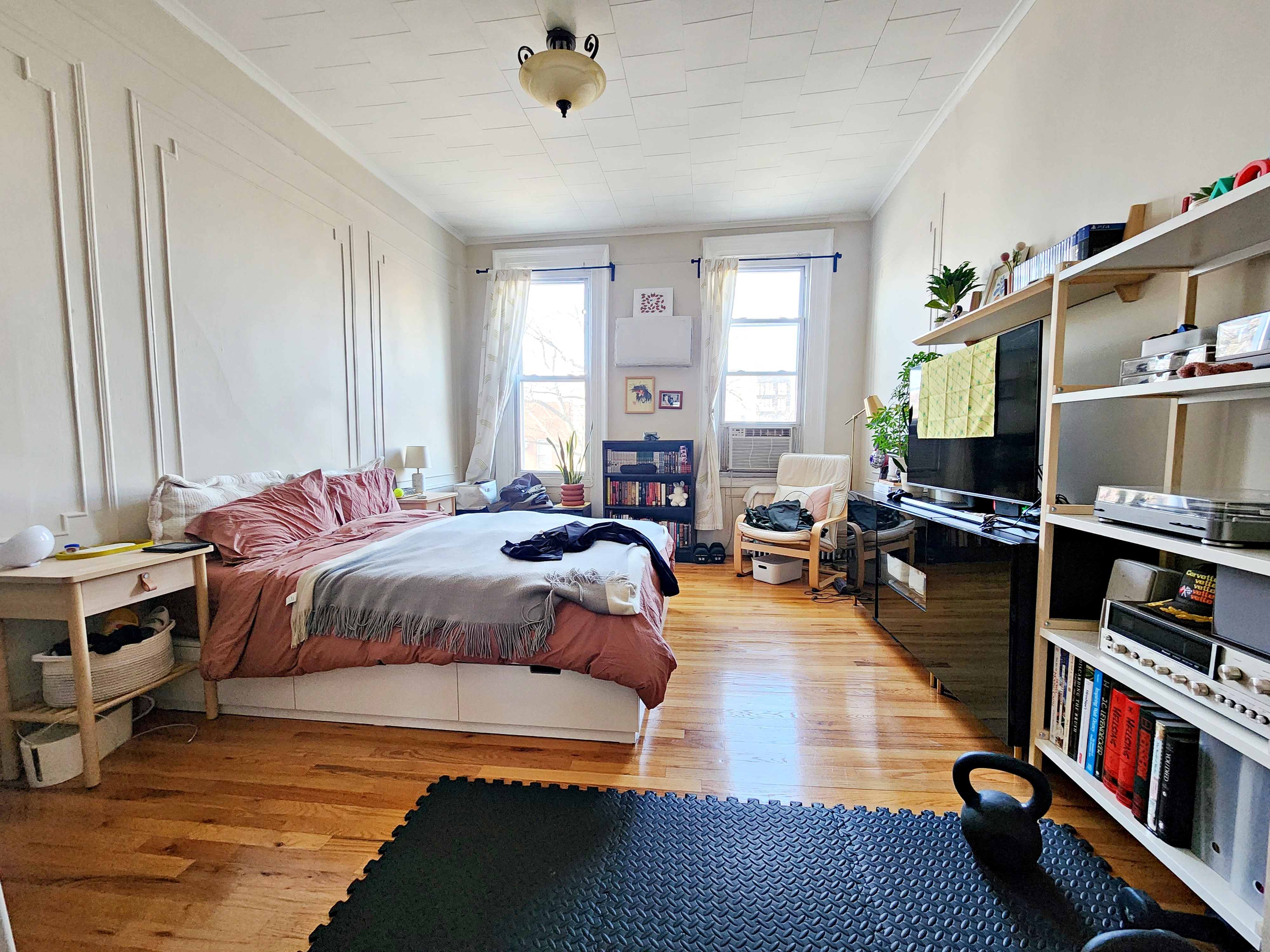 a bedroom with a bed a dresser and a book shelf