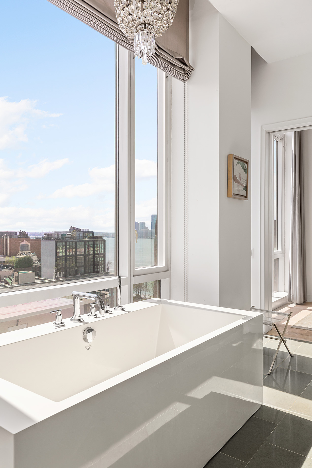 330 Spring Street, Unit PH Manhattan, NY 10013 - Photo 14 of 23 a view of a bathroom with a tub and a large window
