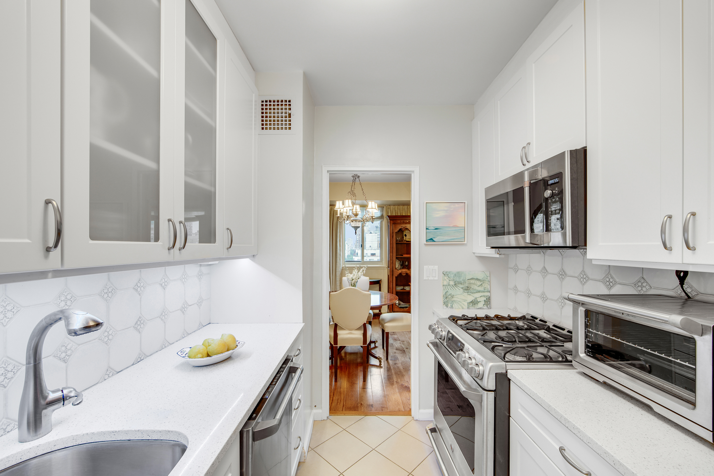 401 East 65th Street, Unit 16C Manhattan, NY 10065 - Photo 5 of 13 a kitchen with a sink and a stove top oven