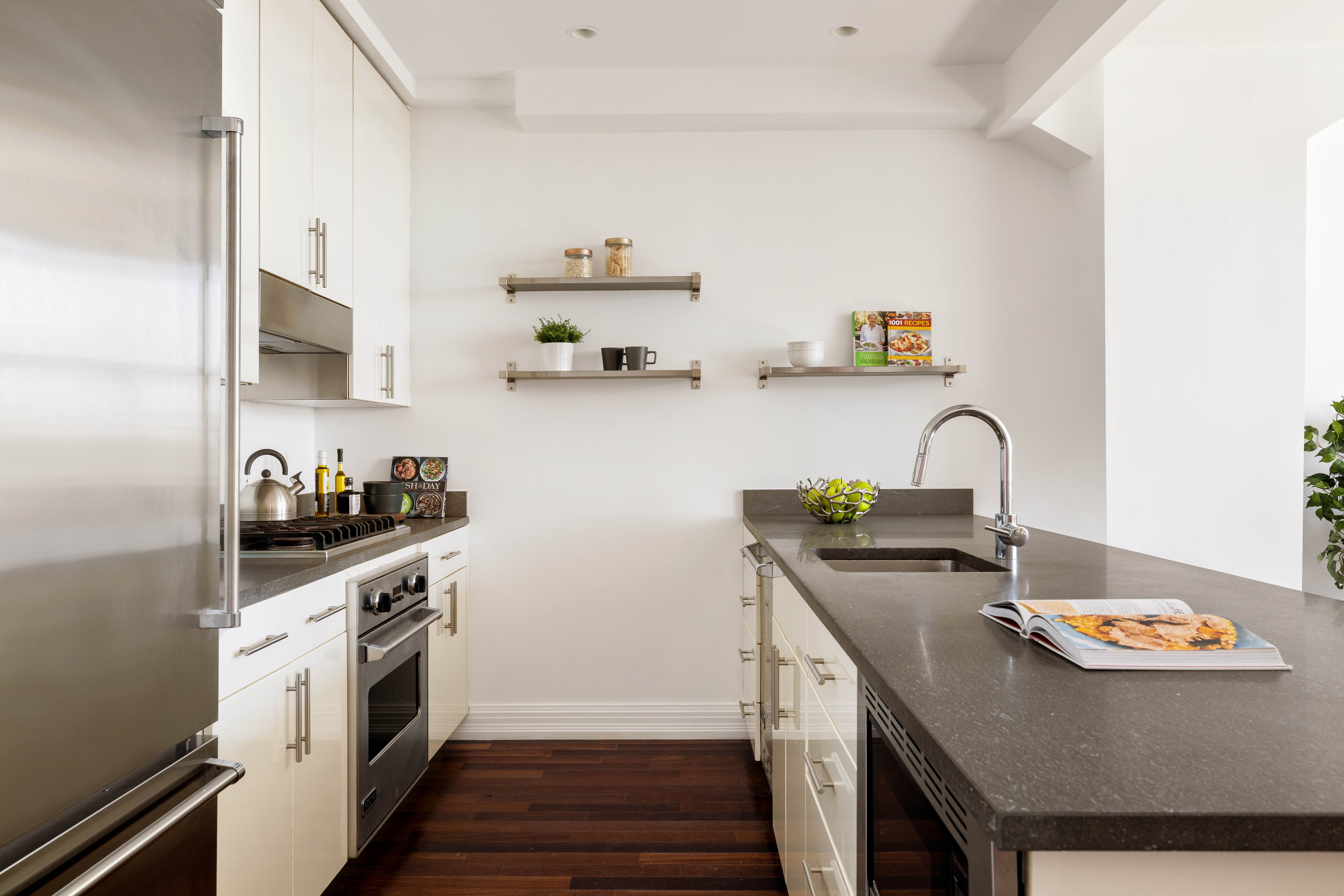 1 Hanson Place, Unit 21C Brooklyn, NY 11243 - Photo 5 of 15 a kitchen with stainless steel appliances a stove a sink and a refrigerator