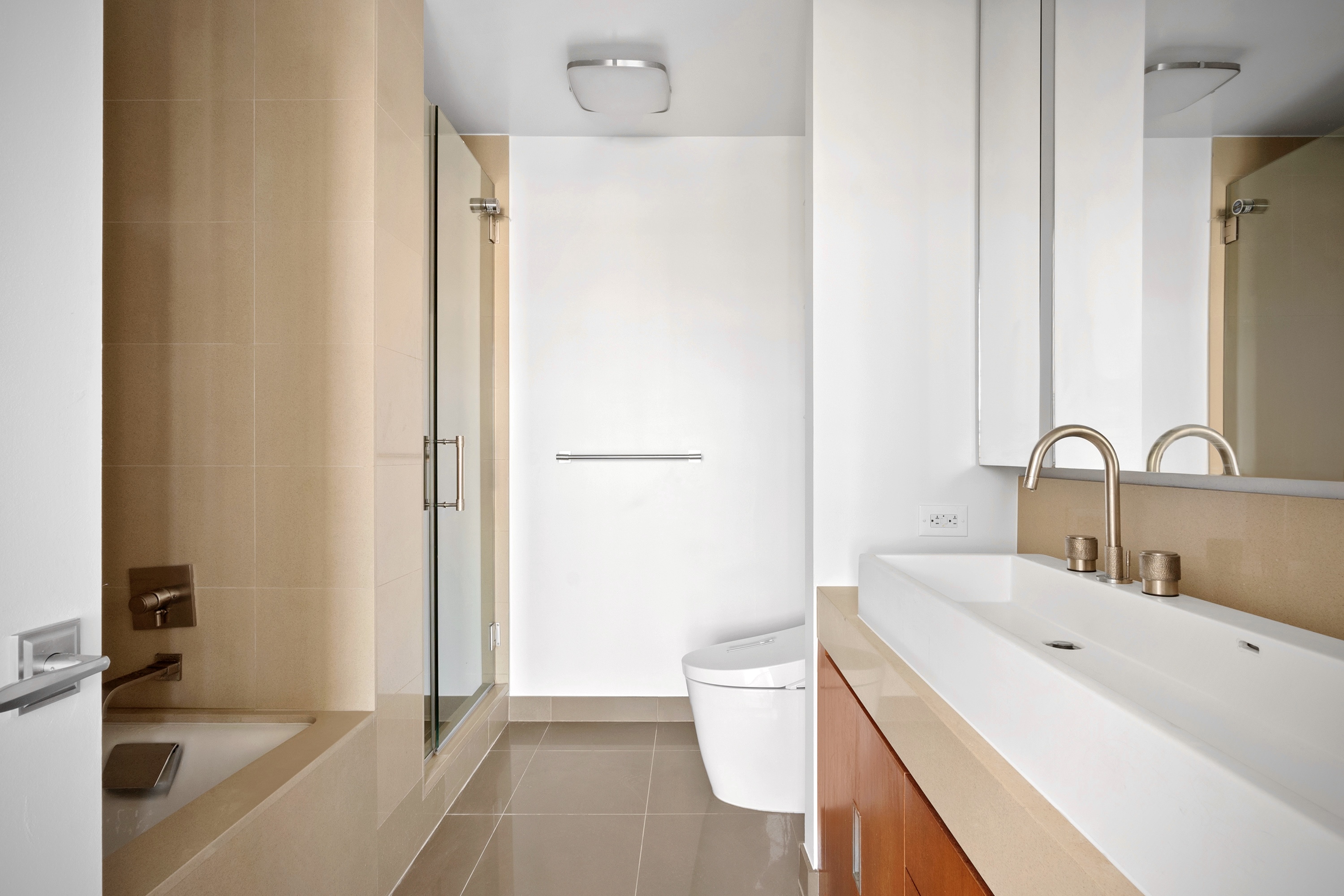 450 West 17th Street, Unit 2003 Manhattan, NY 10011 - Photo 6 of 7 a bathroom with a sink a toilet and a tub