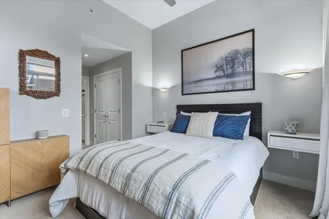 a bedroom with a bed and a lamp on dresser