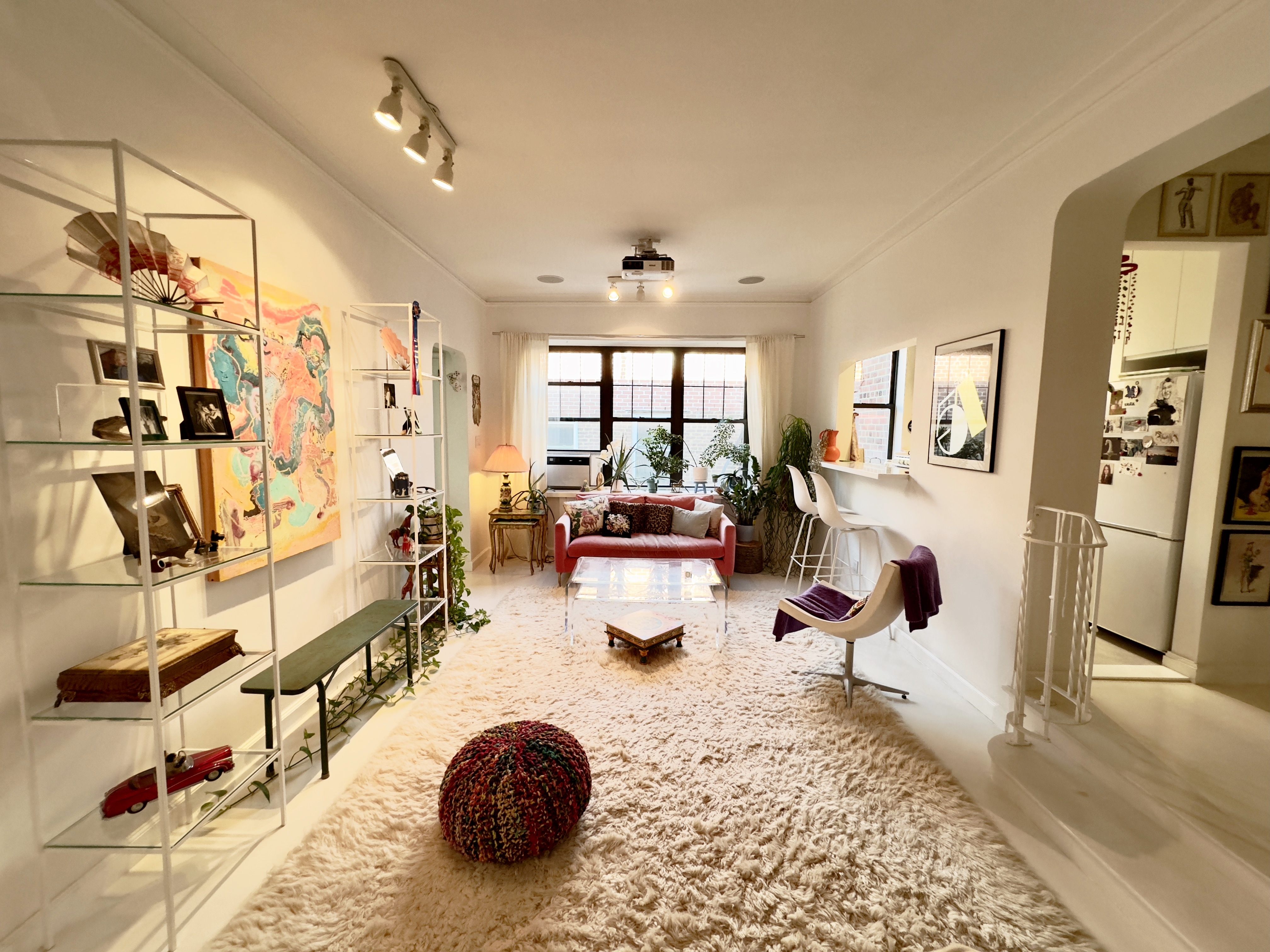 a room with lots of white furniture and a rug