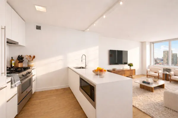 a view of a kitchen with a stove and a view of living room