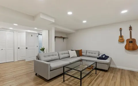 a living room with furniture and a wooden floor