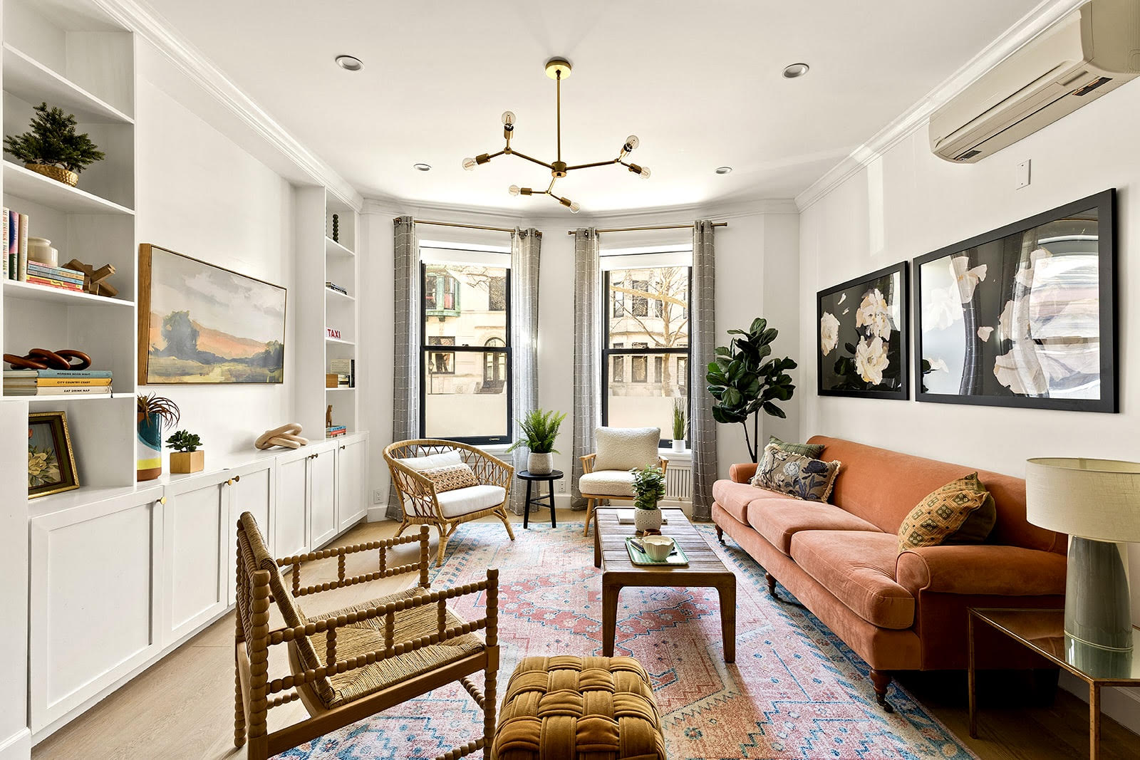 a living room with furniture a chandelier and a large window