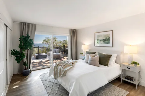 a bedroom with a large bed and a potted plant