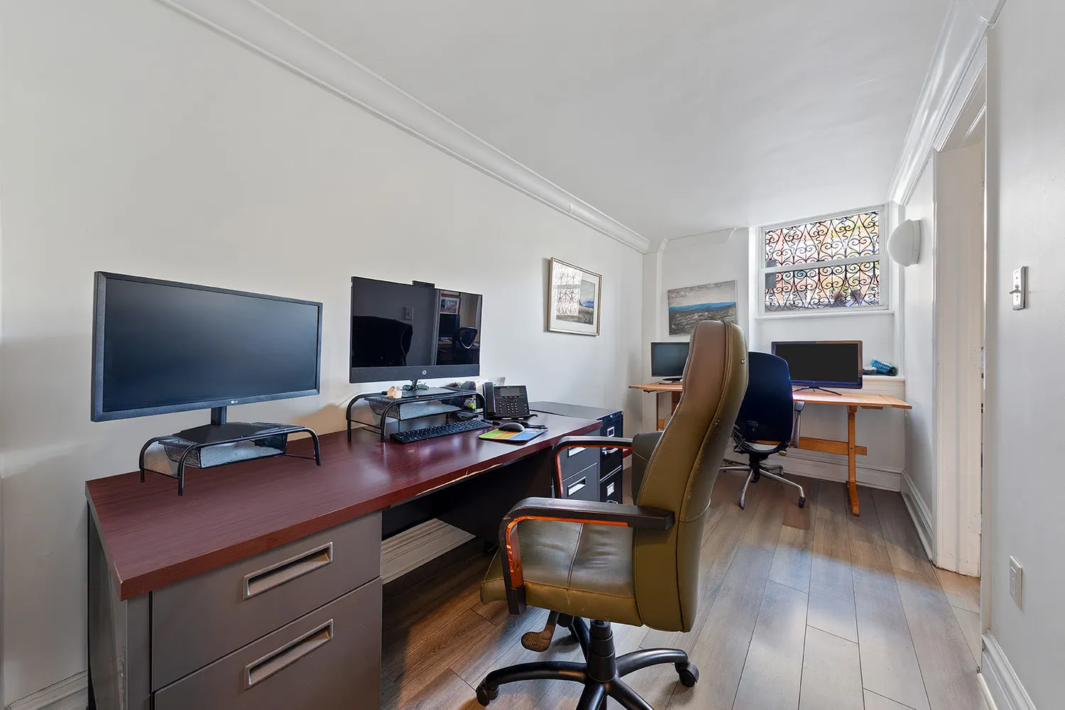 a view of a workspace with furniture and wooden floor