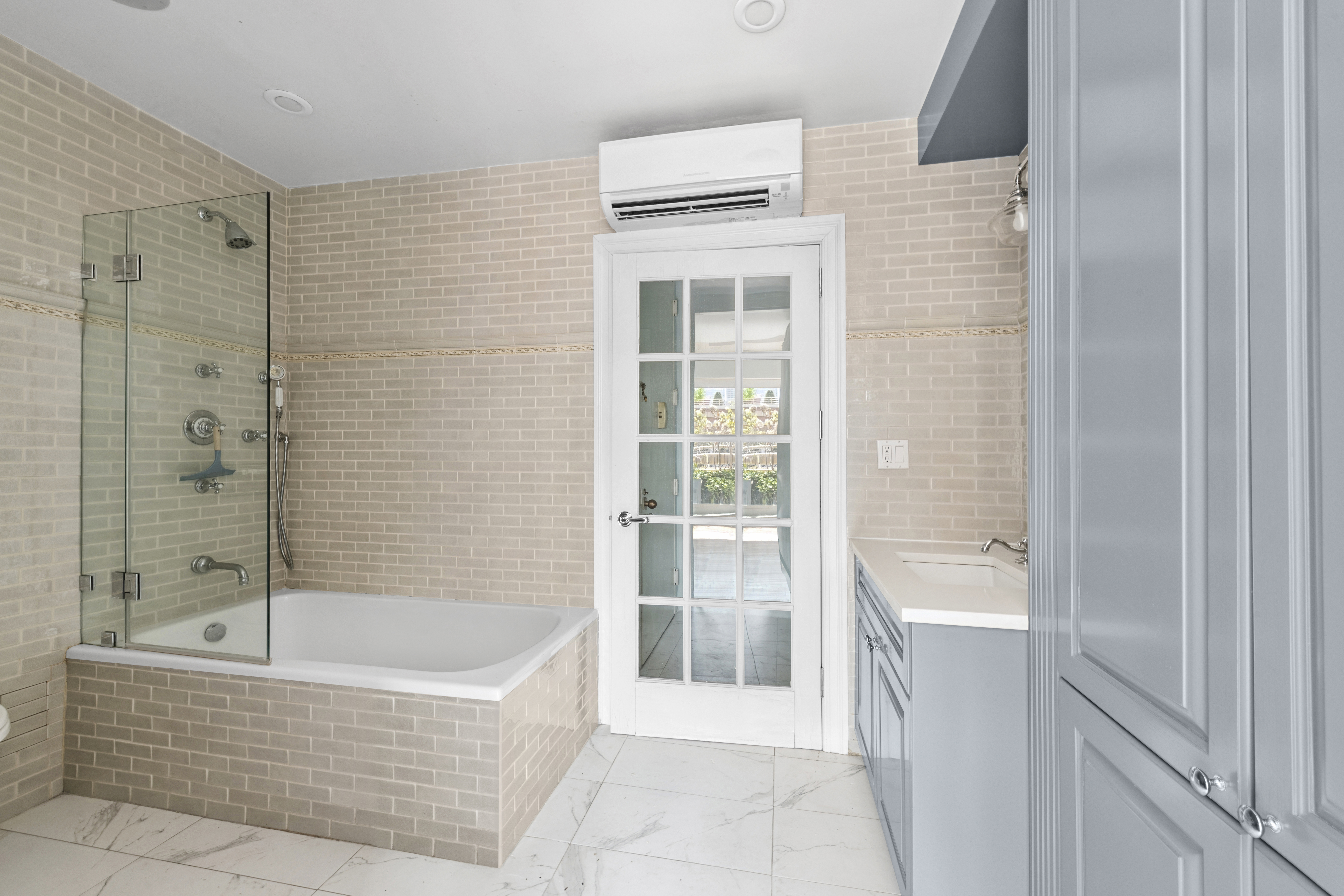 393 West 49th Street, Unit 5NN Manhattan, NY 10019 - Photo 10 of 13 a bathroom with a bathtub and shower