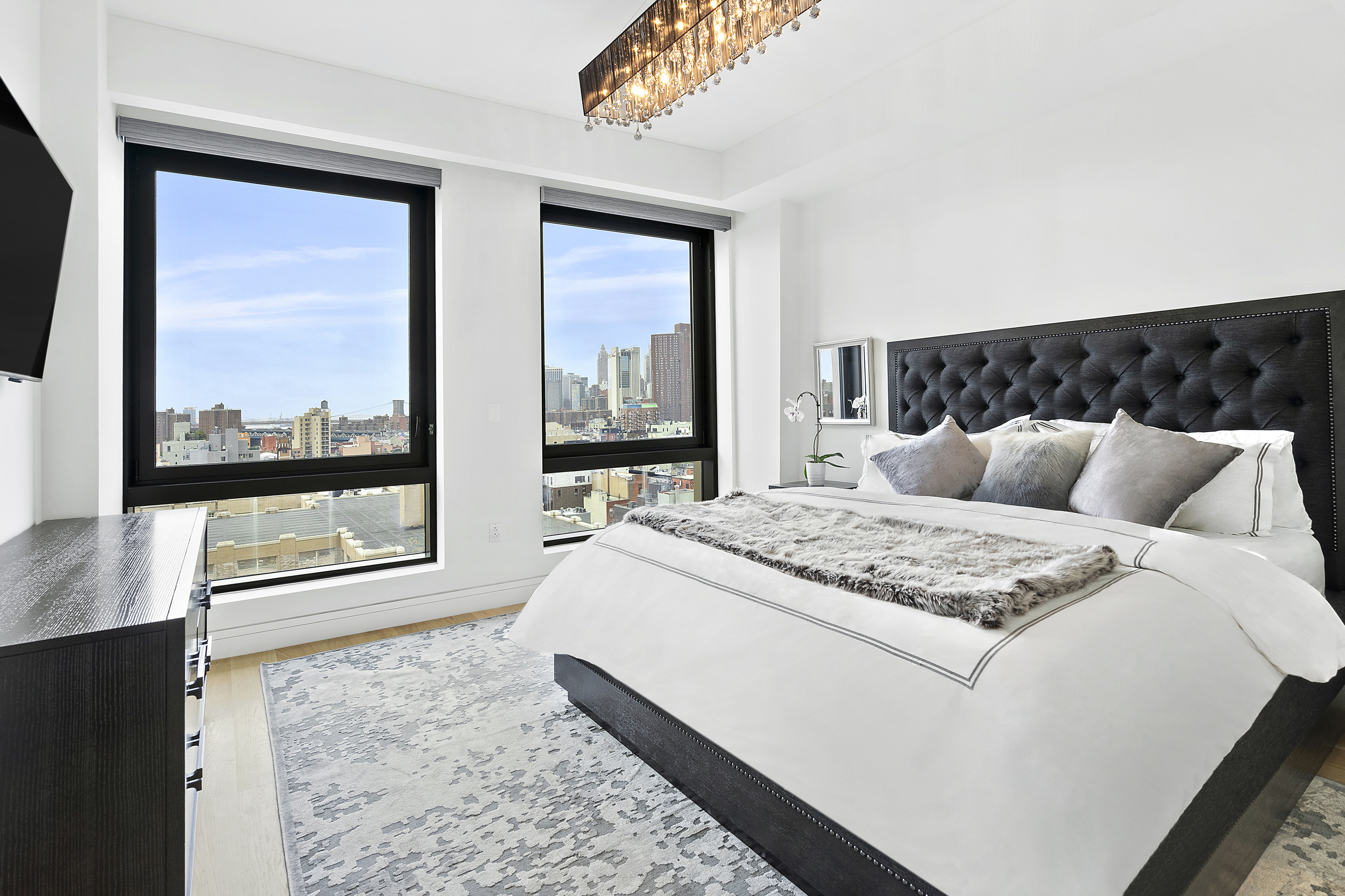 242 Broome Street, Unit 14A Manhattan, NY 10002 - Photo 4 of 6 a bedroom with a large bed and a large window