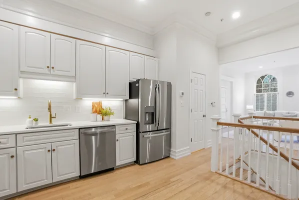 a kitchen with kitchen island a counter top space a sink and a refrigerator