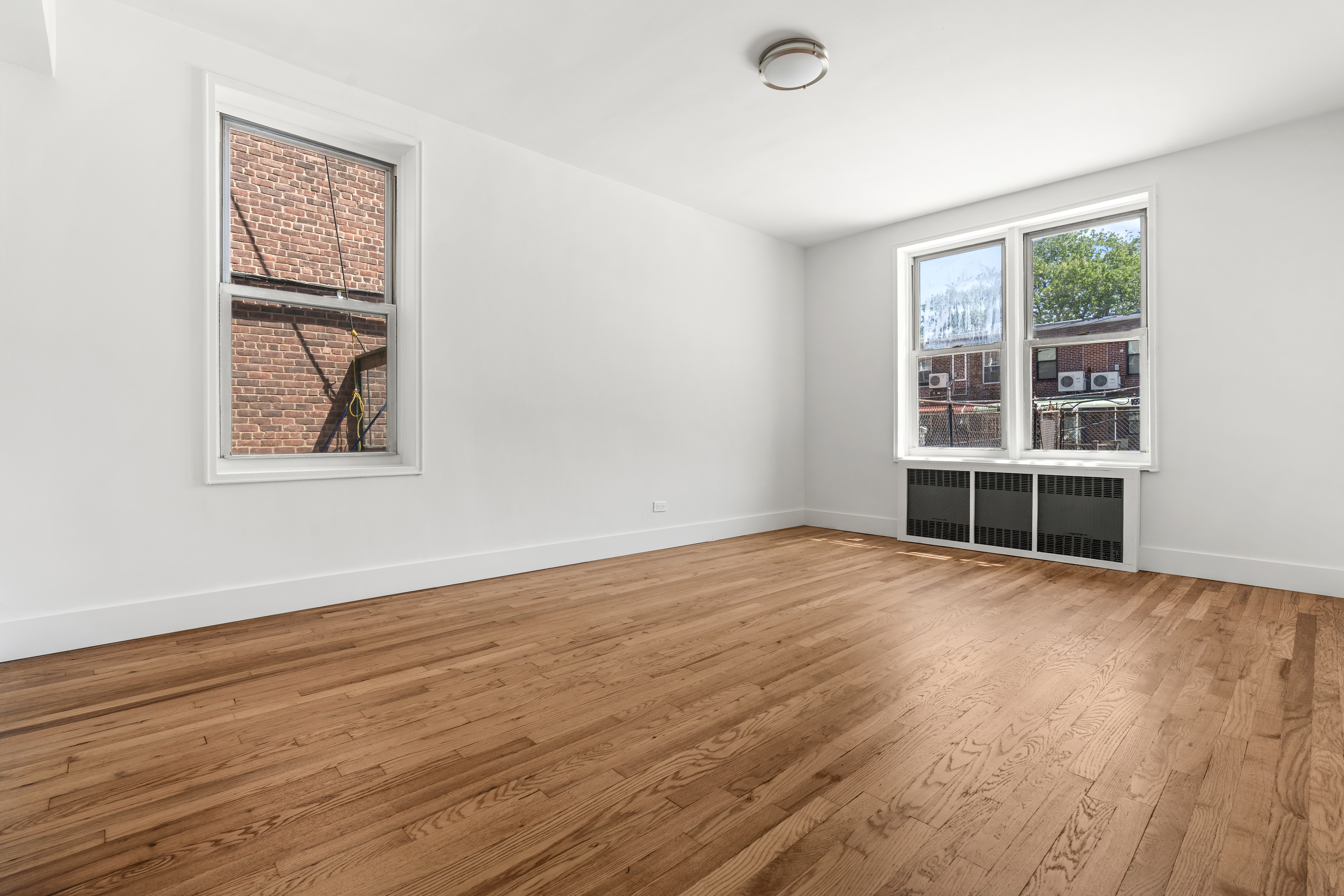 3165 Nostrand Avenue, Unit 1H Brooklyn, NY 11229 - Photo 4 of 9 an empty room with wooden floor and windows