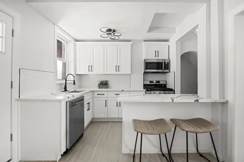 a kitchen with stainless steel appliances granite countertop a stove a sink and a refrigerator