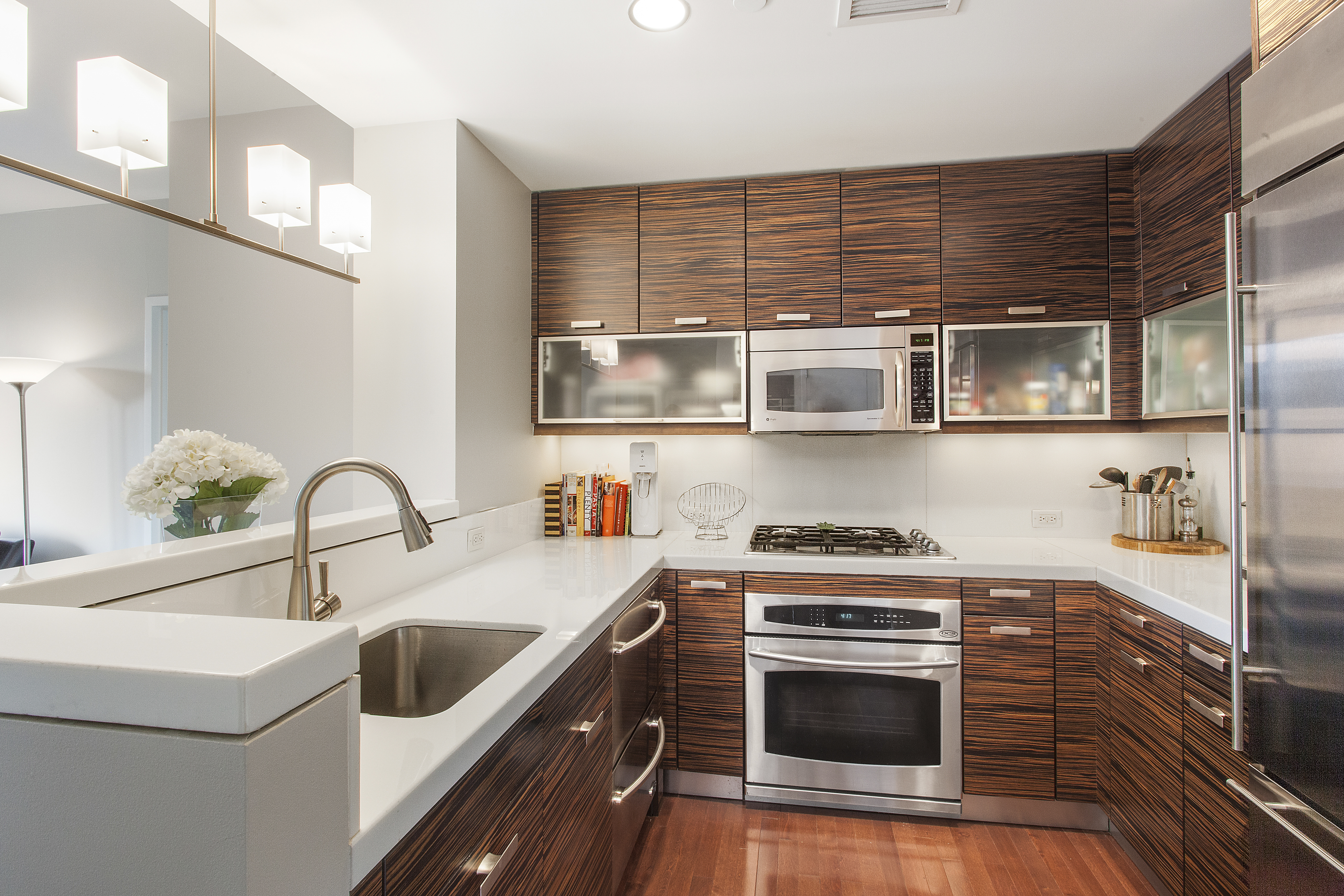 225 East 34th Street, Unit 17C Manhattan, NY 10016 - Photo 2 of 19 a kitchen with stainless steel appliances a stove a sink and a microwave