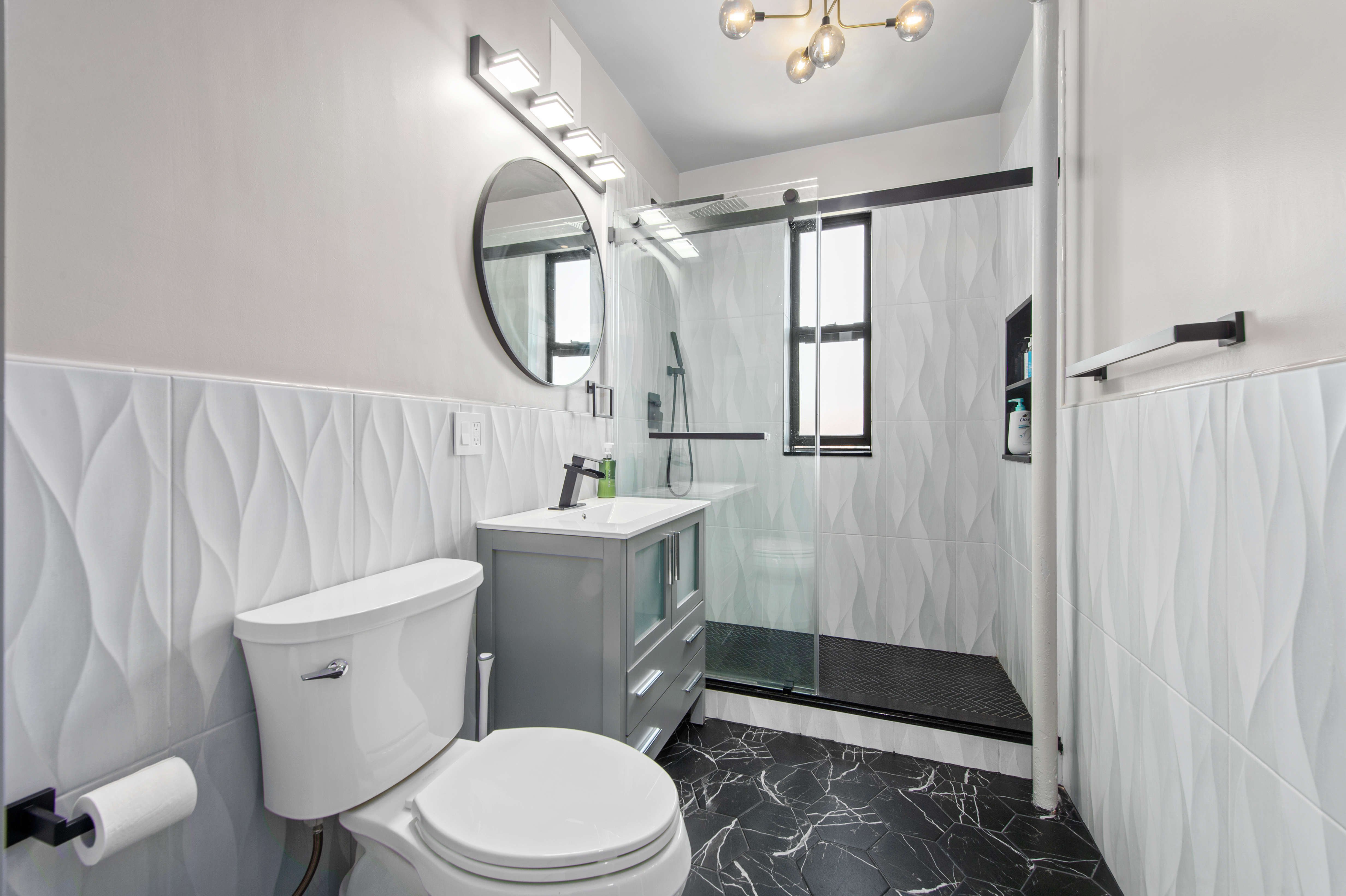 35-06 88th Street, Unit 6B Queens, NY 11372 - Photo 7 of 9 a bathroom with a toilet a sink and a mirror