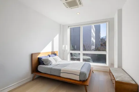 a bedroom with a bed and a large window