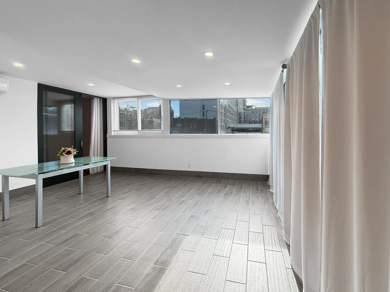 a view of a big room with wooden floor and windows
