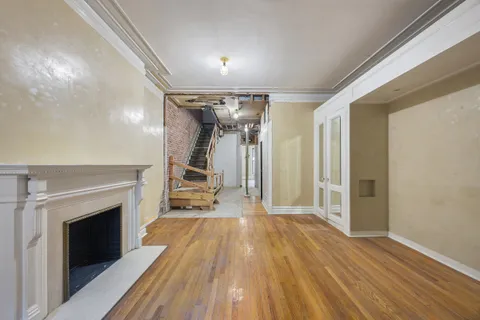 a view of a livingroom with wooden floor and a fireplace