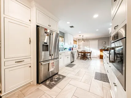 a kitchen with stainless steel appliances granite countertop a refrigerator and a sink