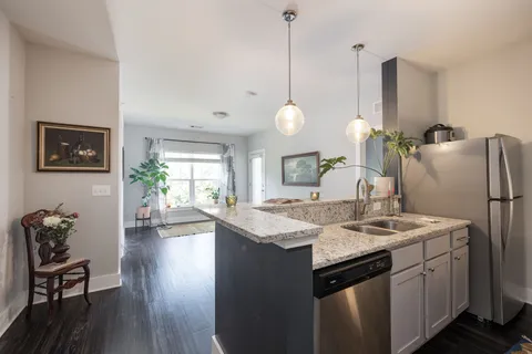 a kitchen with stainless steel appliances granite countertop a stove a kitchen island a table and chairs