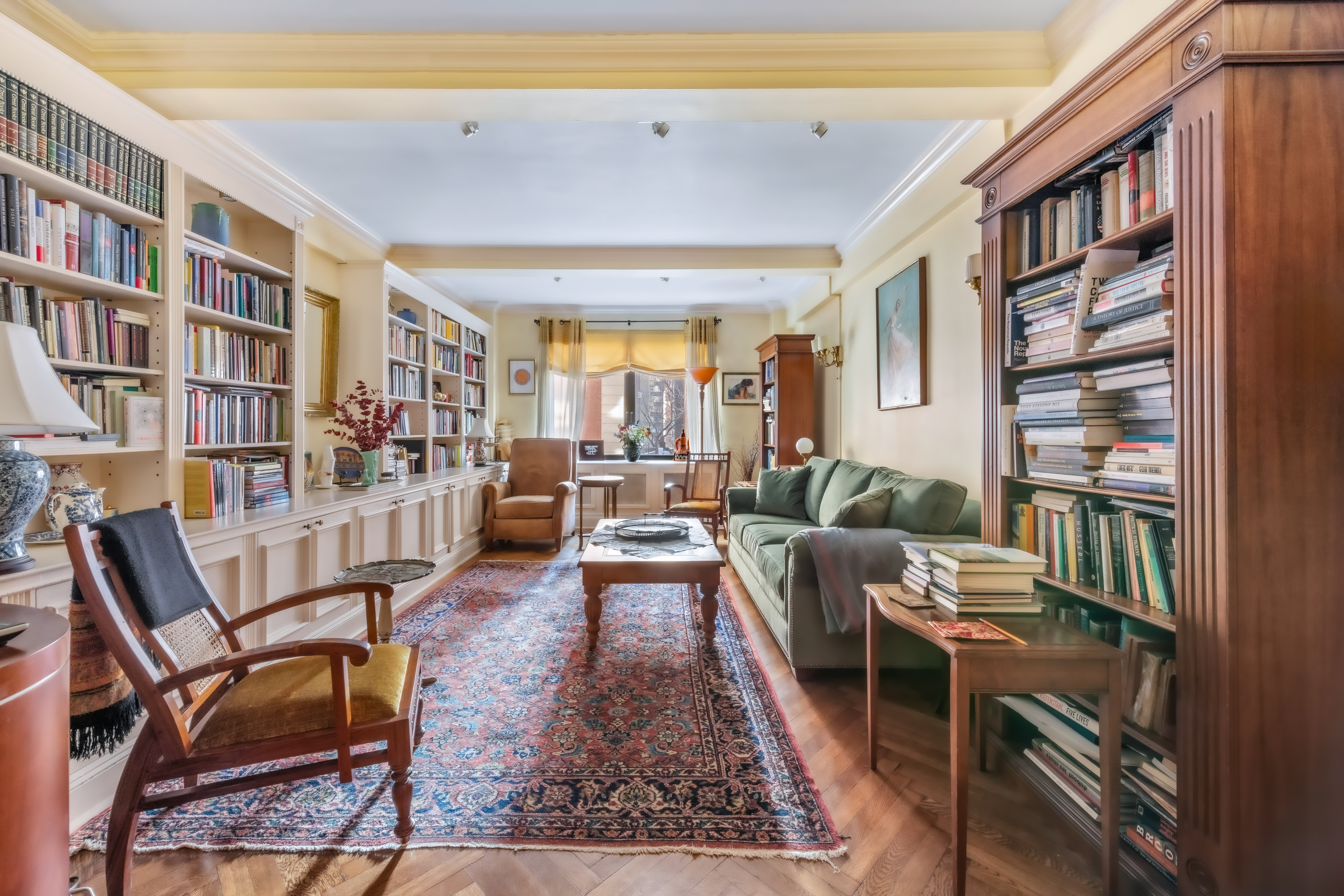 a living room with furniture and a book shelf
