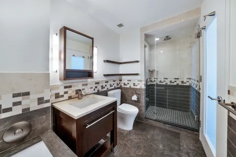 a bathroom with a sink toilet double vanity and tub