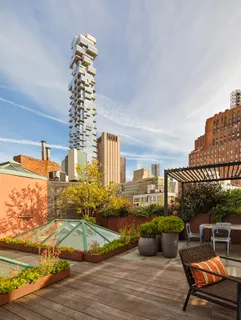 a view of a rooftop deck with couch and chairs
