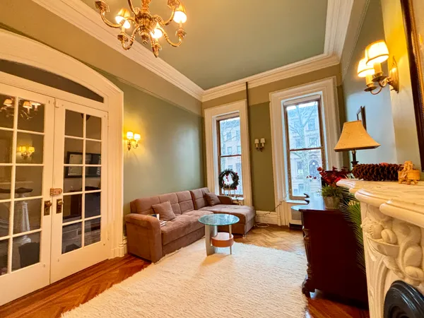a living room with furniture a chandelier and a large window