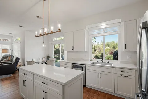 a kitchen with sink cabinets and chandelier