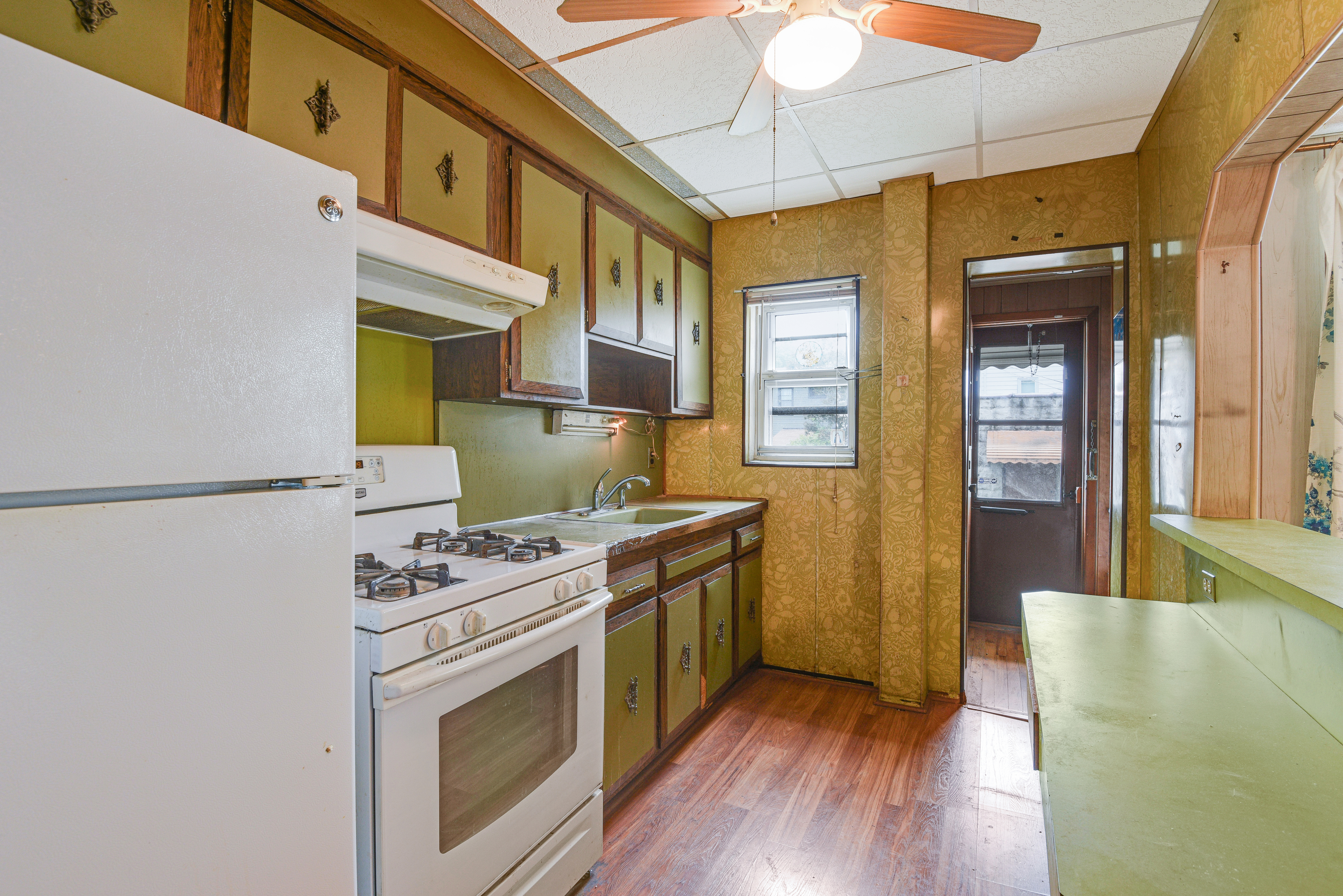 75-36 60th Lane Queens, NY 11385 - Photo 7 of 18 a kitchen with a stove top oven cabinets a sink and a refrigerator