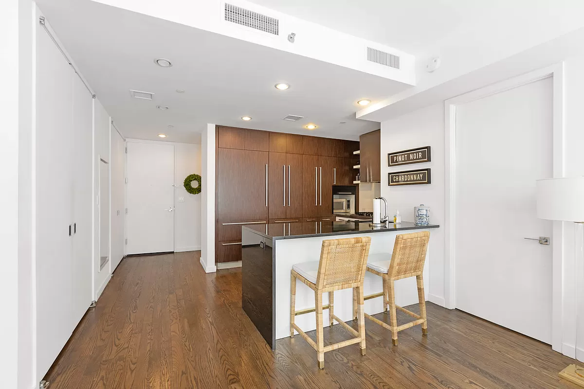 133 West 22nd Street, Unit 12B Manhattan, NY 10011 - Photo 2 of 12 a view of a kitchen with dining space and wooden floor