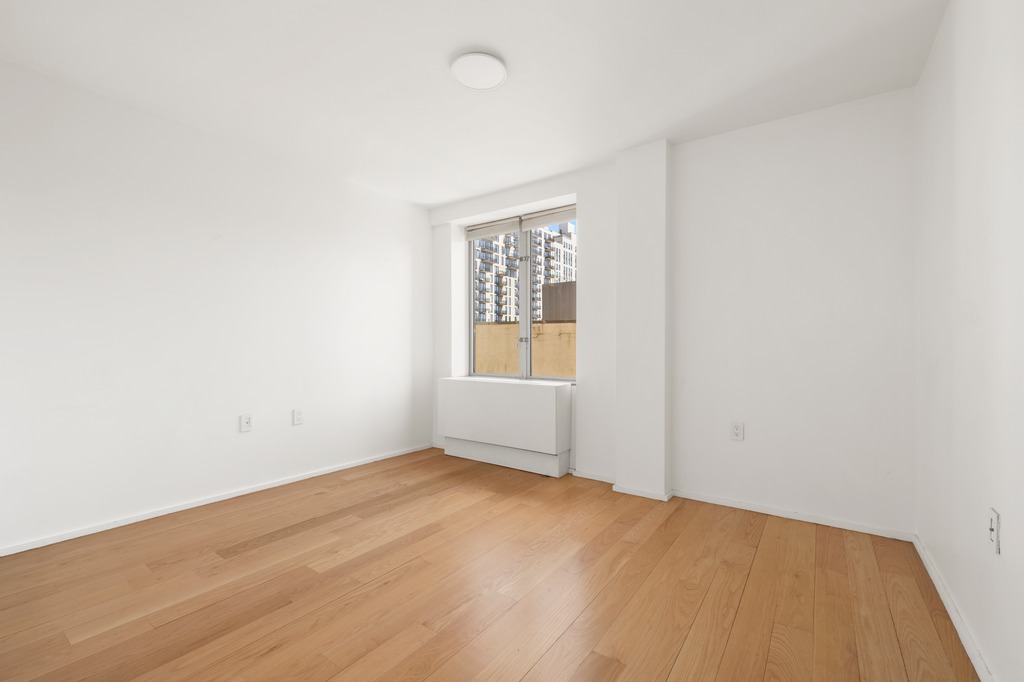 2280 Frederick Douglass Boulevard, Unit 6A Manhattan, NY 10027 - Photo 12 of 13 an empty room with wooden floor and windows
