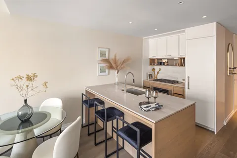 a kitchen with stainless steel appliances kitchen island a table and chairs in it