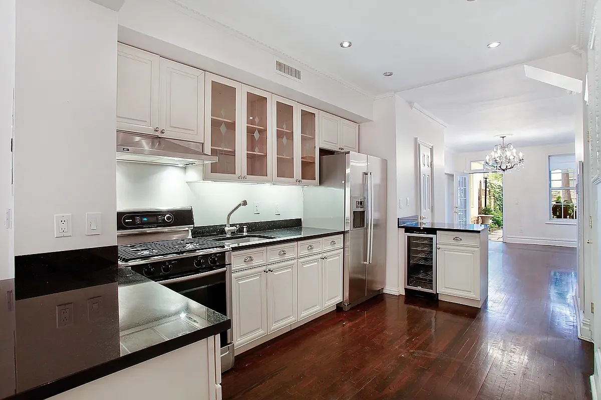 177 East 70th Street Manhattan, NY 10021 - Photo 10 of 14 a kitchen with stainless steel appliances granite countertop a stove and a refrigerator