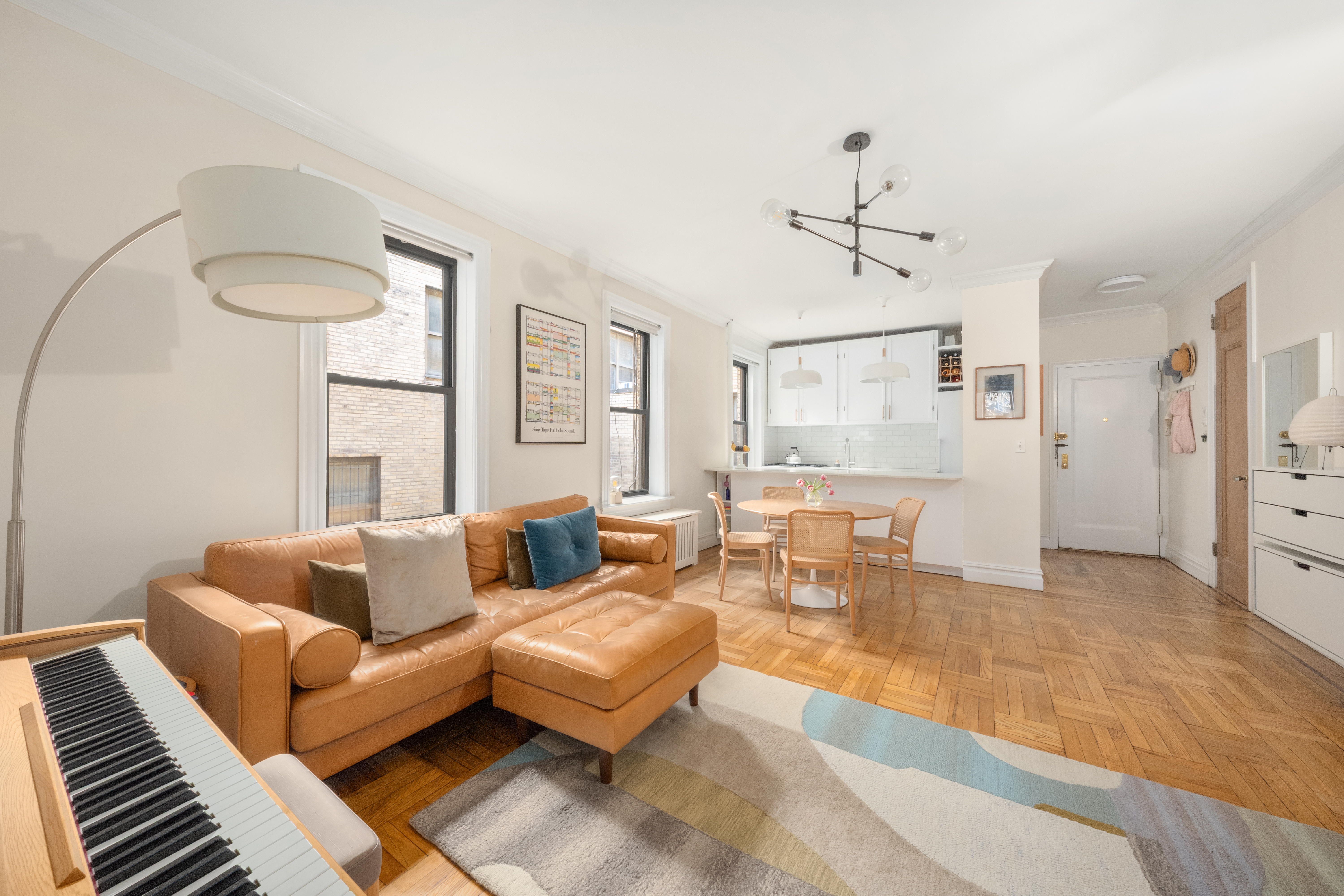 a living room with furniture a chandelier and a rug