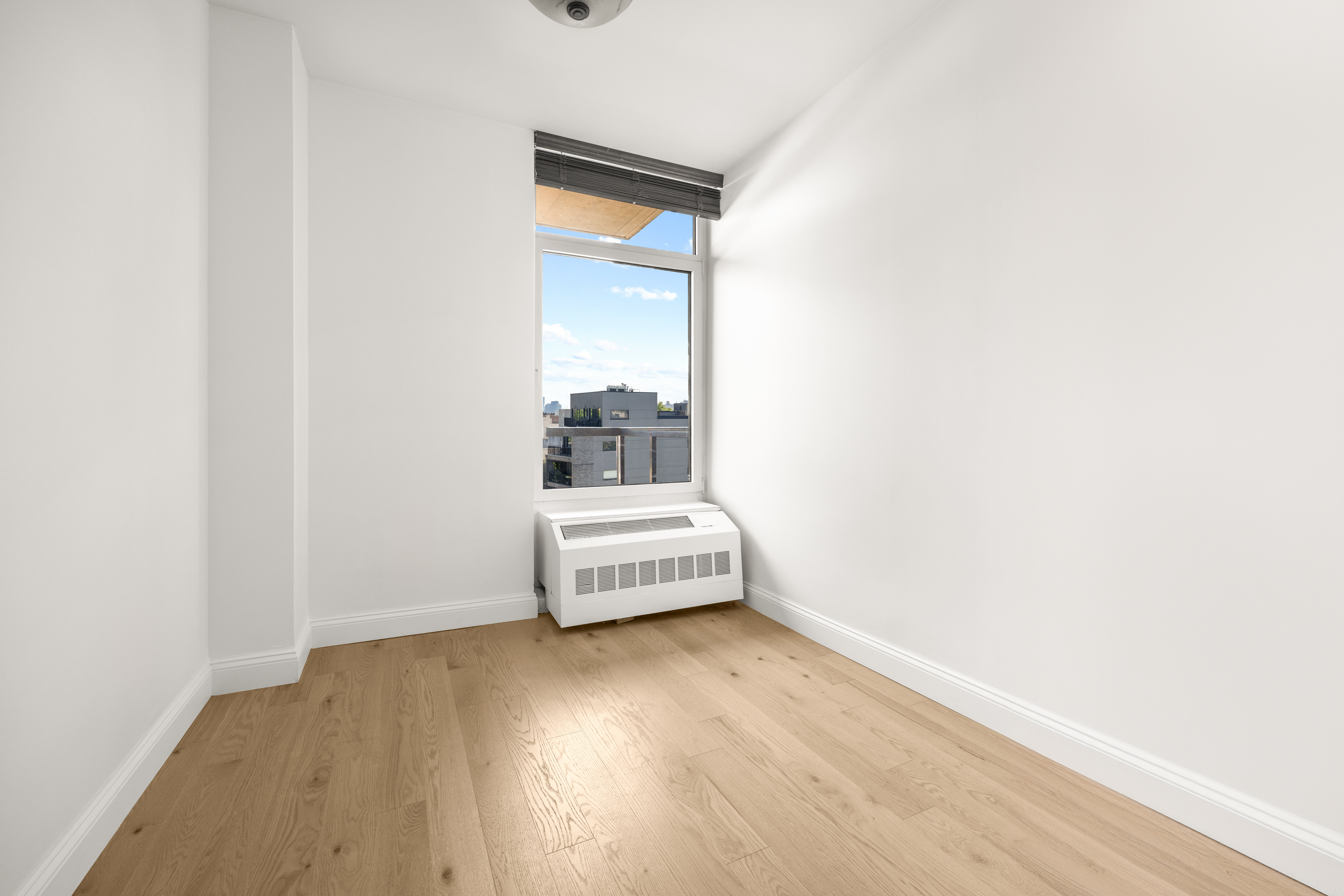 162 16th Street, Unit 7E Brooklyn, NY 11215 - Photo 9 of 23 a view of an empty room with wooden floor and a window