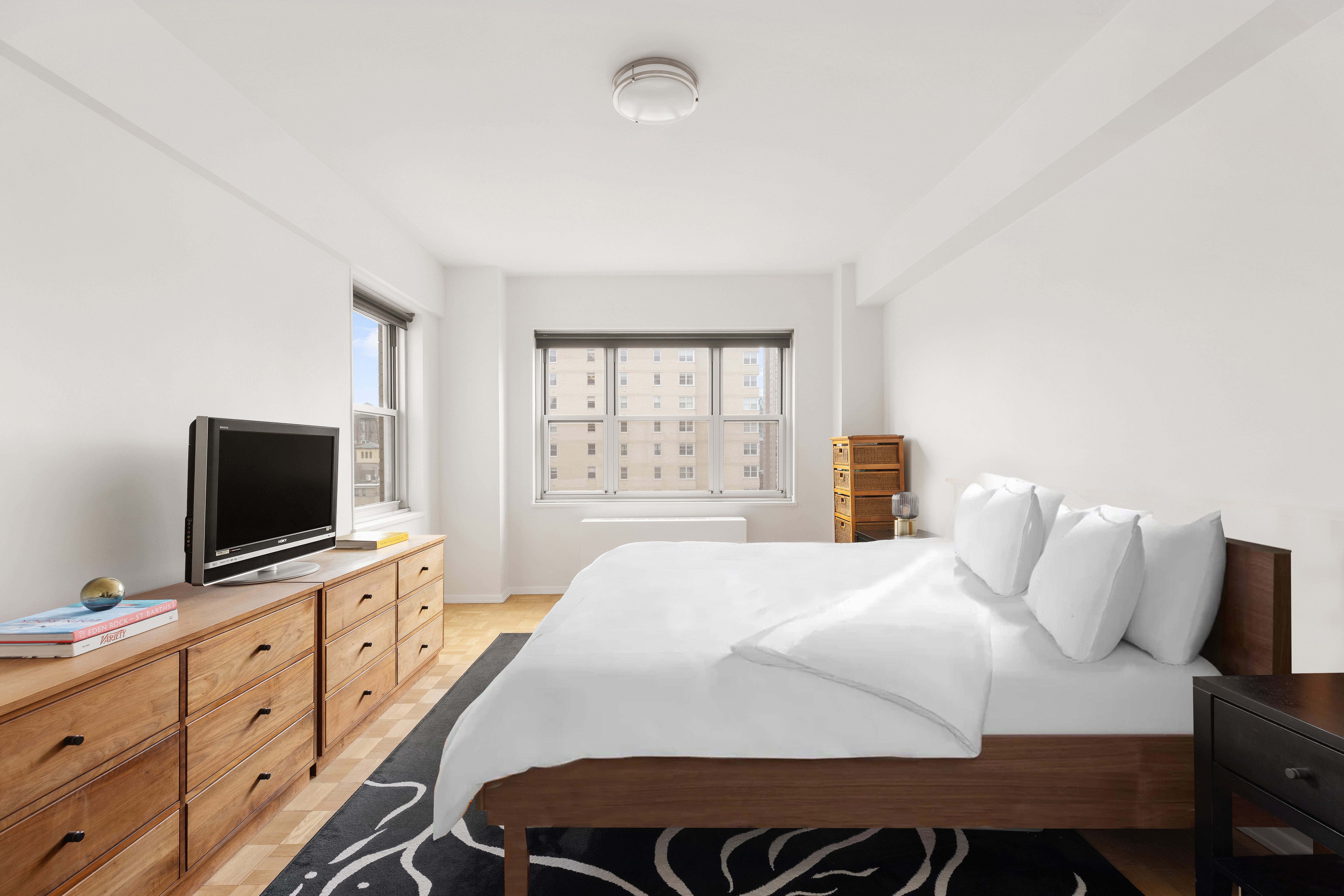 11 5th Avenue, Unit 18A Manhattan, NY 10003 - Photo 4 of 11 a bedroom with a bed and a flat screen tv