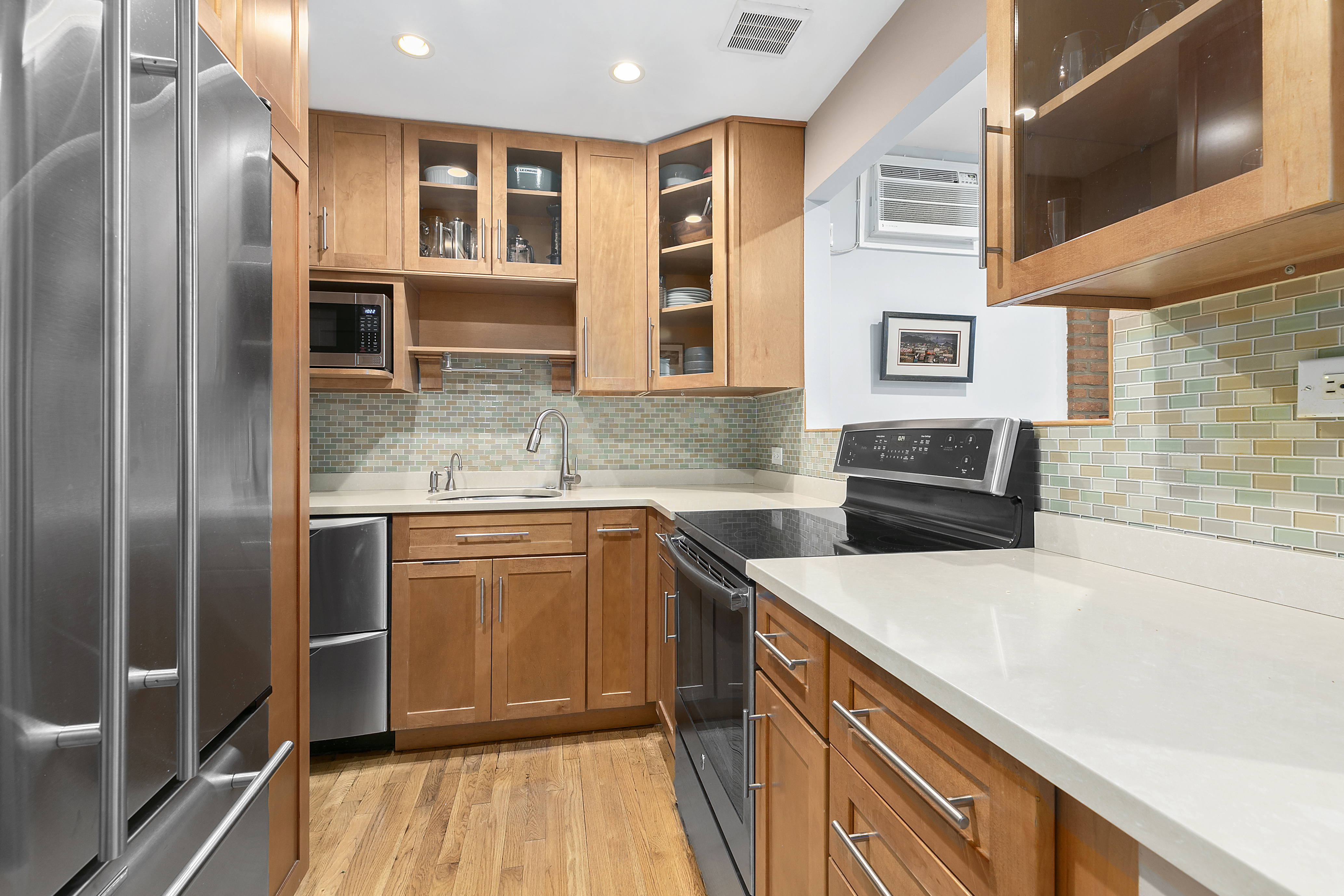 255 West 95th Street, Unit 1B Manhattan, NY 10025 - Photo 3 of 12 a kitchen with stainless steel appliances granite countertop a sink and dishwasher a refrigerator with wooden floor