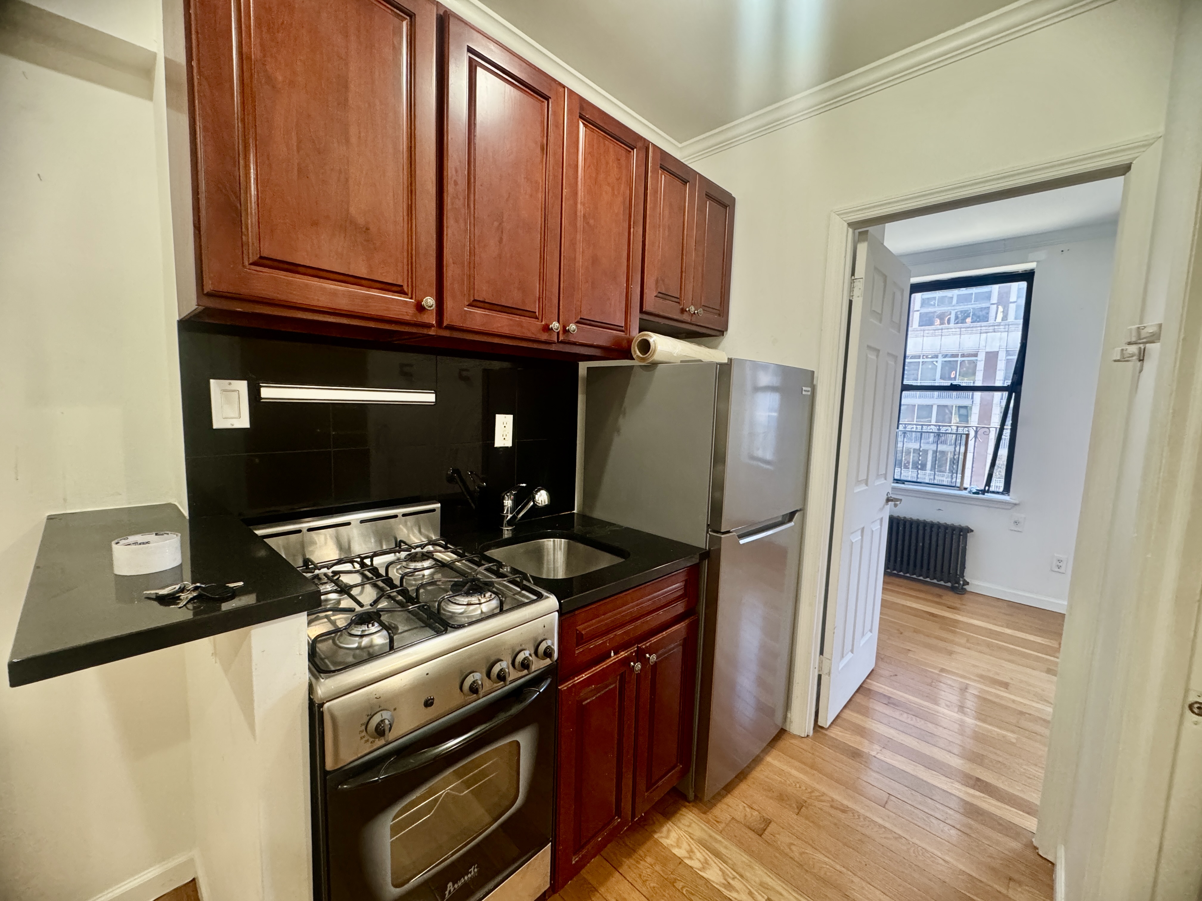 1773 1st Avenue, Unit 18 Manhattan, NY 10128 - Photo 2 of 10 a kitchen with stainless steel appliances granite countertop a stove refrigerator and cabinets